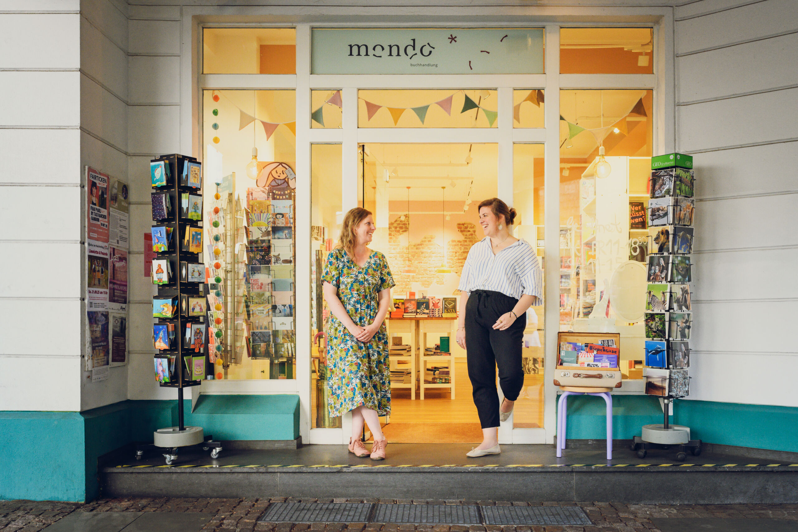 Mari und Anna stehen vor dem Eingang der Buchhandlung